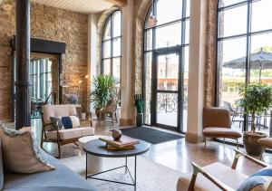 a living room with chairs and tables and windows at Lora in Stillwater