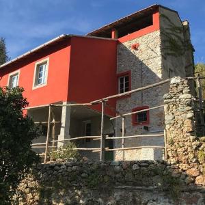 ein rotes Haus mit einer Steinmauer in der Unterkunft Ca'Russa - La Vanvera in Finale Ligure