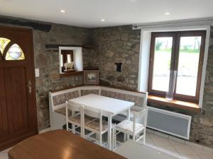 cocina con mesa, sillas y ventana en Charmante maison entre Terre et Mer, en Plouaret