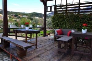 a wooden deck with benches and tables and a view at Casa Fiorita in Gragnano