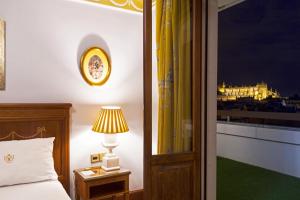 a bedroom with a bed and a lamp and a window at Hotel Inglaterra in Seville +47 photos