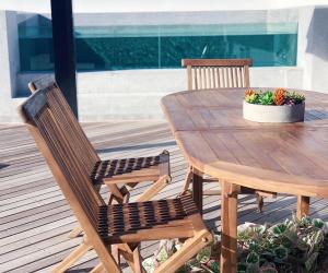 uma mesa de madeira com duas cadeiras e um vaso de plantas em Luxury Onyx Penthouse with Sea Mountain Views by CTICC Cape Town em Cidade do Cabo