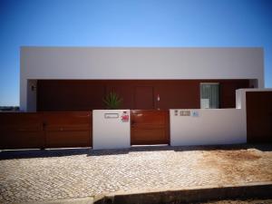 an empty room with a white refrigerator and cabinets at Suites da Ria in Mexilhoeira Grande