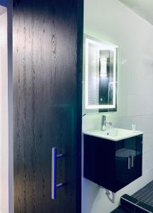 een badkamer met een wastafel en een houten deur bij Modern Suite #1 Pasavento in Aguadilla