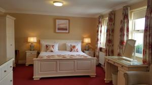 a bedroom with a large white bed with two pillows at The Moorings Hotel & Seafood Restaurant in Portmagee