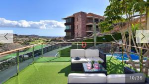 サン・バルトロメにあるVilla Las Terrazas 17•Exclusive Chill Out and Pool.の白い家具付きのバルコニーが備わり、建物の景色を望めます。