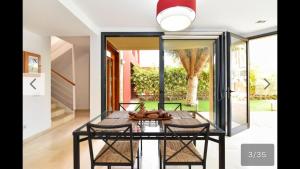 comedor con mesa de cristal y sillas en Villa Las Terrazas 17•Exclusive Chill Out and Pool., en San Bartolomé