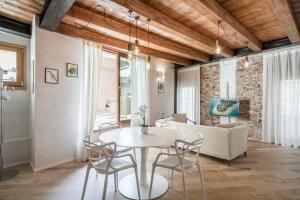 a dining room and living room with a table and chairs at Crocus Apartments in Sirmione