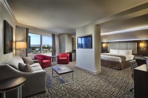 a hotel room with a bed and a couch and chair at The STRAT Hotel, Casino and SkyPod in Las Vegas