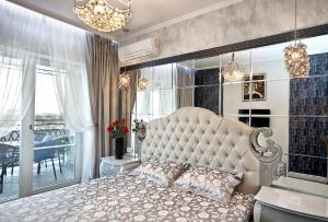 een slaapkamer met een groot bed en een groot raam bij Beach & Beatles Apartments in Odessa