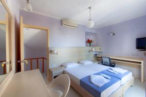 a bedroom with a bed and a table and chairs at Giorgi's Blue Apartments in Kalathas