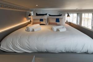 uma cama grande com lençóis brancos e almofadas em Hiding Space - Trim Street Apartments em Bath