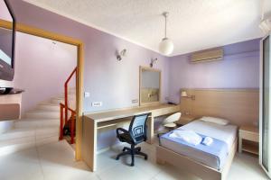 a bedroom with a bed and a desk and a chair at Giorgi's Blue Apartments in Kalathas