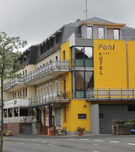 ein gelbes Gebäude mit einem Schild darauf in der Unterkunft Hotel Pohl in Kinheim