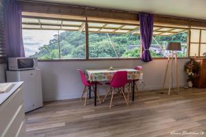 une cuisine avec une table et des chaises ainsi qu'une fenêtre dans l'établissement Fare Matatia, à Punaauia