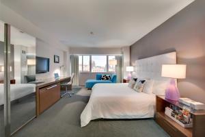 a hotel room with a large bed and a desk at Hotel Murano in Tacoma