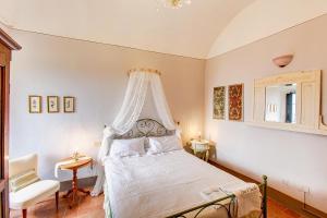 - une chambre avec un lit blanc à baldaquin dans l'établissement La Rocca, à Gambassi Terme