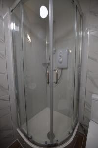 a shower with a glass door in a bathroom at PremierLux Serviced Apartments in Ilford +58 photos