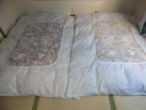 a bed with two pillows on top of it at Minshuku Nakano in Fujiyoshida