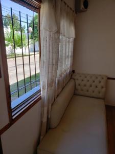 um sofá sentado em frente a uma janela em Complejo La Naranjita em Rosário