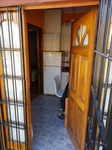 an open door to a kitchen with a refrigerator at Complejo La Naranjita in Rosario +100 photos