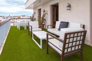 
a white couch sitting on top of a green lawn at Hotel Inglaterra in Seville
