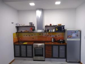 a kitchen with a stove and a refrigerator at Casa confortable in Córdoba