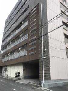 een gebouw in een straat met een parkeergarage bij Lipelala Stay 505 in Osaka