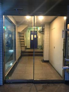 um corredor vazio com uma porta de vidro num edifício em Lipelala Stay 505 em Osaka