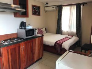 a small room with a bed and a microwave at Al - Minhaj Service Apartments in Nadi