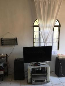 ein Wohnzimmer mit einem Flachbild-TV und Lautsprechern in der Unterkunft Chona and Christophe Guesthouse - Masbate in Masbate
