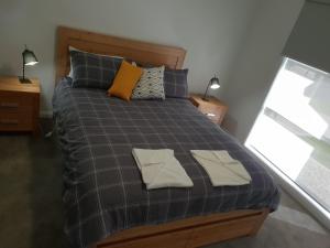 a bedroom with a bed with two towels on it at Wimmera Plains in Horsham