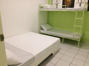 a small room with two beds and a shelf at Dormitels.ph Ermita in Manila