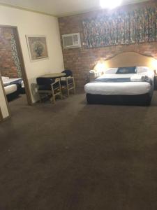 Habitación de hotel con cama y mesa en Pines Country Club Motor Inn, en Shepparton