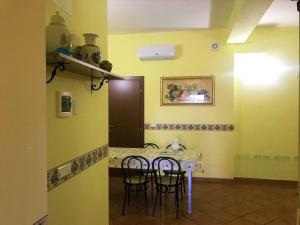 a room with a table with two chairs and a counter at B&B Teodora in Gaggi