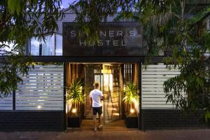 a man standing in the doorway of a store at Spinners Hostel in Perth