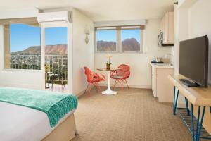 une chambre d'hôtel avec un lit, une table et des chaises dans l'établissement Queen Kapiolani Hotel, à Honolulu