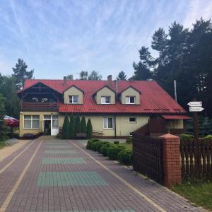 ein Haus mit rotem Dach und Auffahrt in der Unterkunft Ostoya Roztocze in Szczebrzeszyn