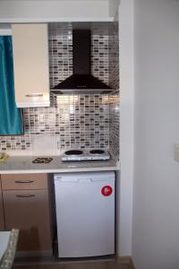 a kitchen with a stove and a white refrigerator at Siesta Garden Apart Hotel in Turgutreis