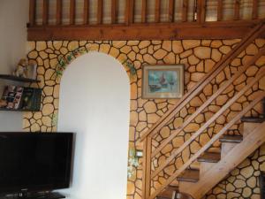 a staircase with a stone wall and a tv at La Jatta in Budoni