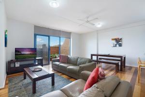 a living room with a couch and a tv at Newcastle Short Stay Accommodation - Sandbar Newcastle Beach in Newcastle