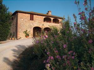 un vecchio edificio in pietra con un mazzo di fiori di Agriturismo Fattoria Di Corsano a Corsano