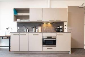 a kitchen with white cabinets and an oven at New Loft Apt View Delft city center balcony Utopia2c in Delft