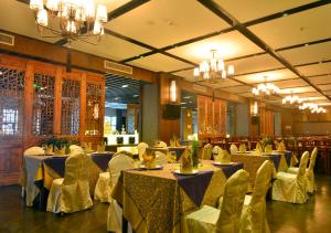 a banquet hall with blue tables and chairs and chandeliers at Barry Boutique Hotel Sanya in Sanya