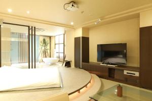 a bedroom with a large bed and a television at C-HOTEL affetto(Adult Only) in Sapporo