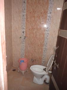 a bathroom with a toilet and a bucket at Hotel Sai Kripa in Jaipur