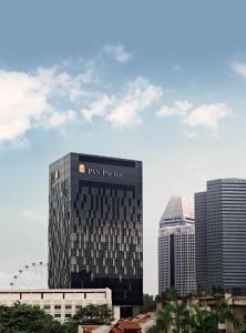 un edificio alto con un cartel en una ciudad en Pan Pacific Serviced Suites Beach Road, Singapore en Singapur