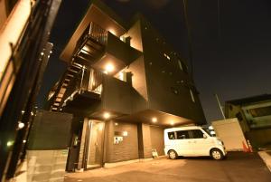 ENZO / Vacation STAY 11623 في فوكوكا: سيارة فان بيضاء متوقفة أمام مبنى في الليل