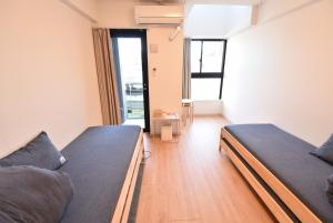 two beds in a room with a large window at ENZO / Vacation STAY 11623 in Fukuoka