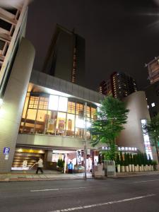 un edificio con una persona caminando delante de él por la noche en Urawa Washington Hotel, en Saitama